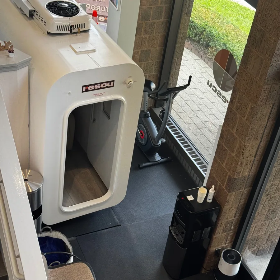 Seated hyperbaric chamber with its window and adjacent equipment
